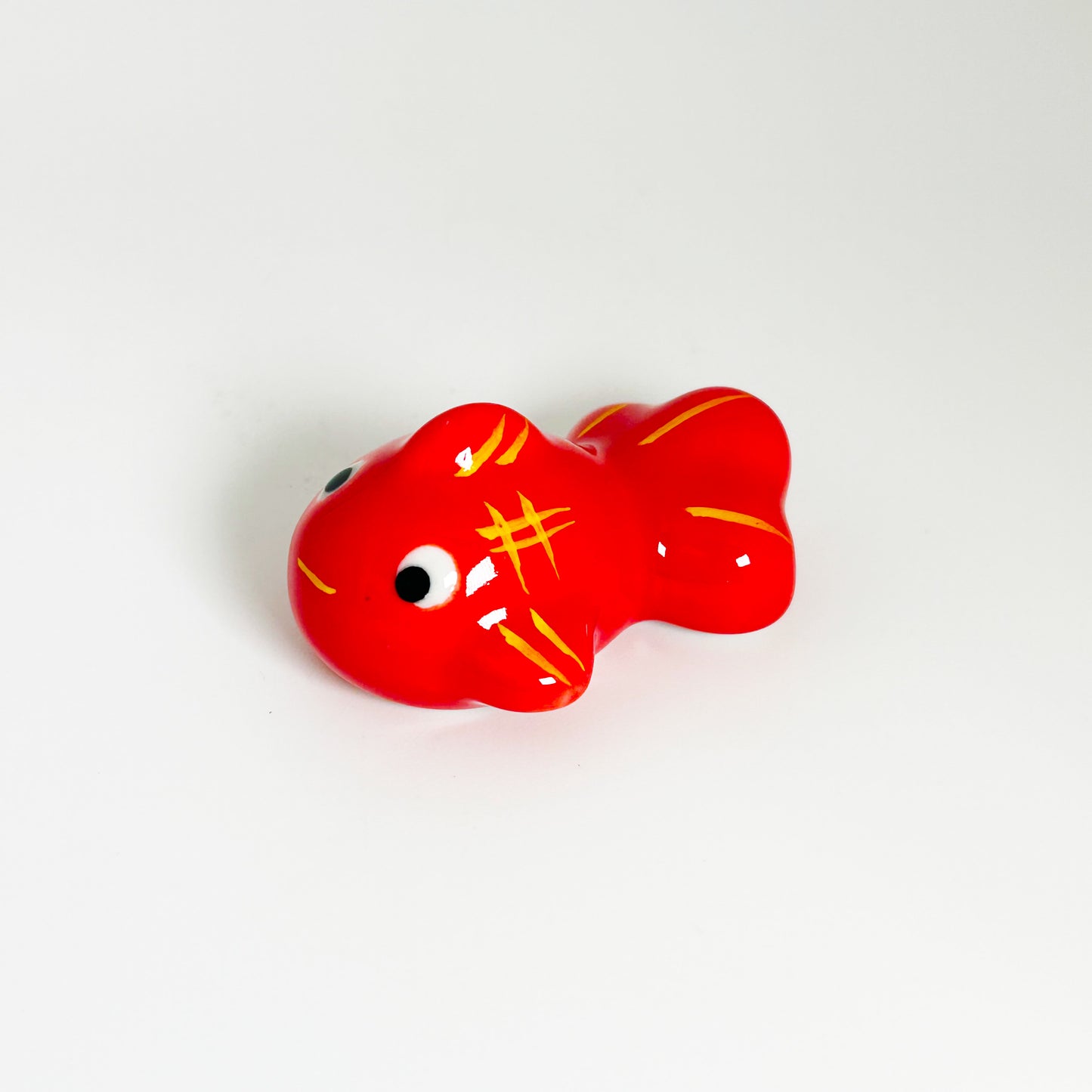 A red goldfish with a white background.