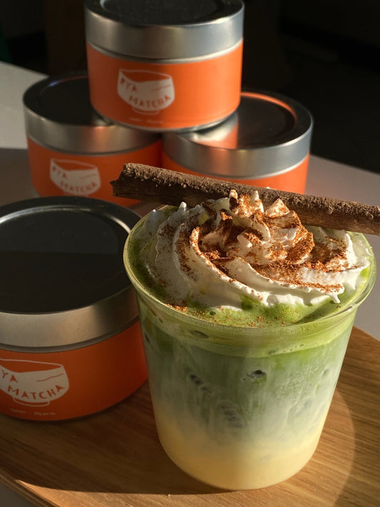 Delicious Egg Nog Matcha Latte with Rya Matcha in front of Rya Matcha Samidori Tins Tins