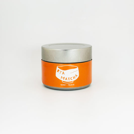 Orange Rya Matcha container with silver lid on a white background. Samidori variety, 30 gram tin.