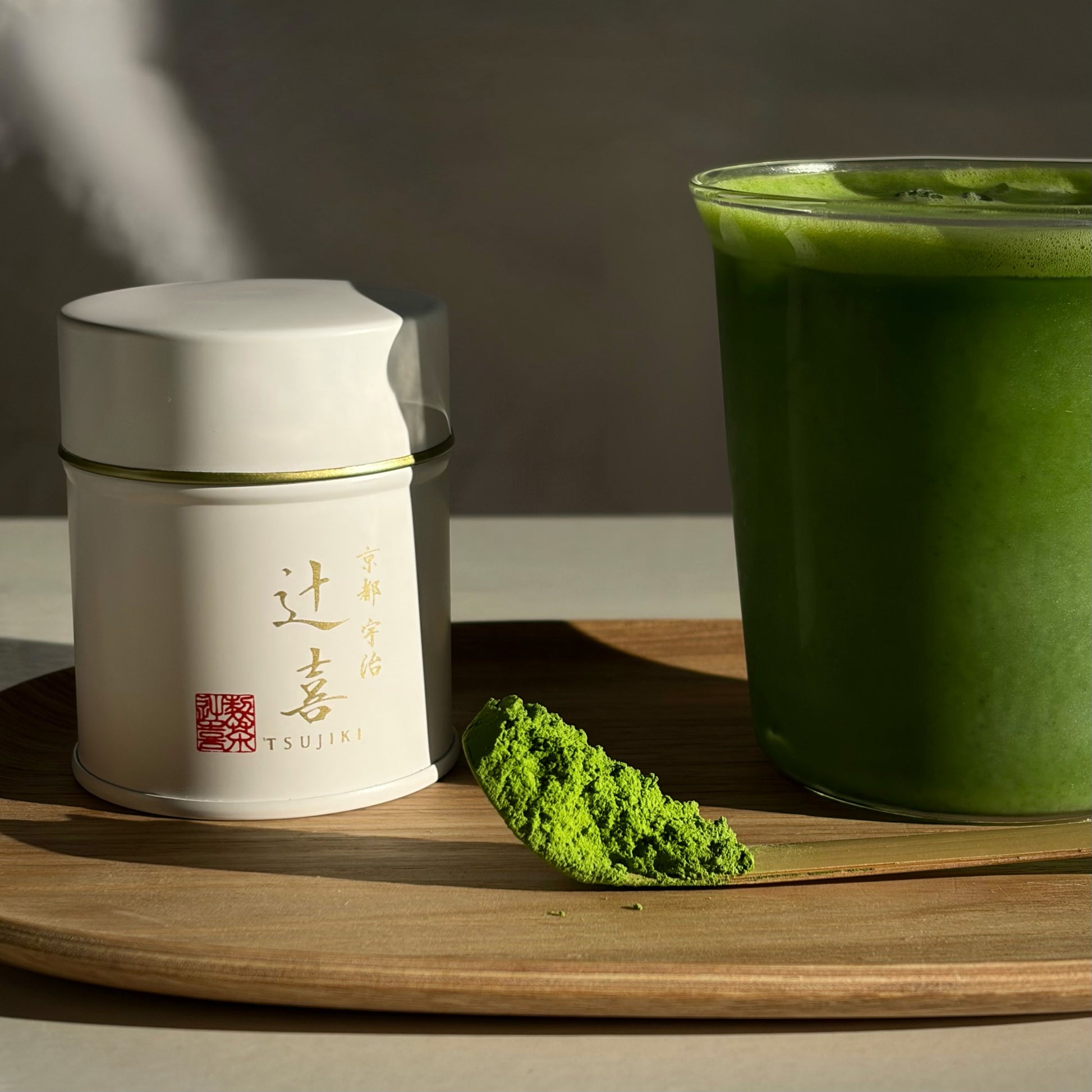 A Okegawa Reserve Blend tin next to powder and a matcha latte