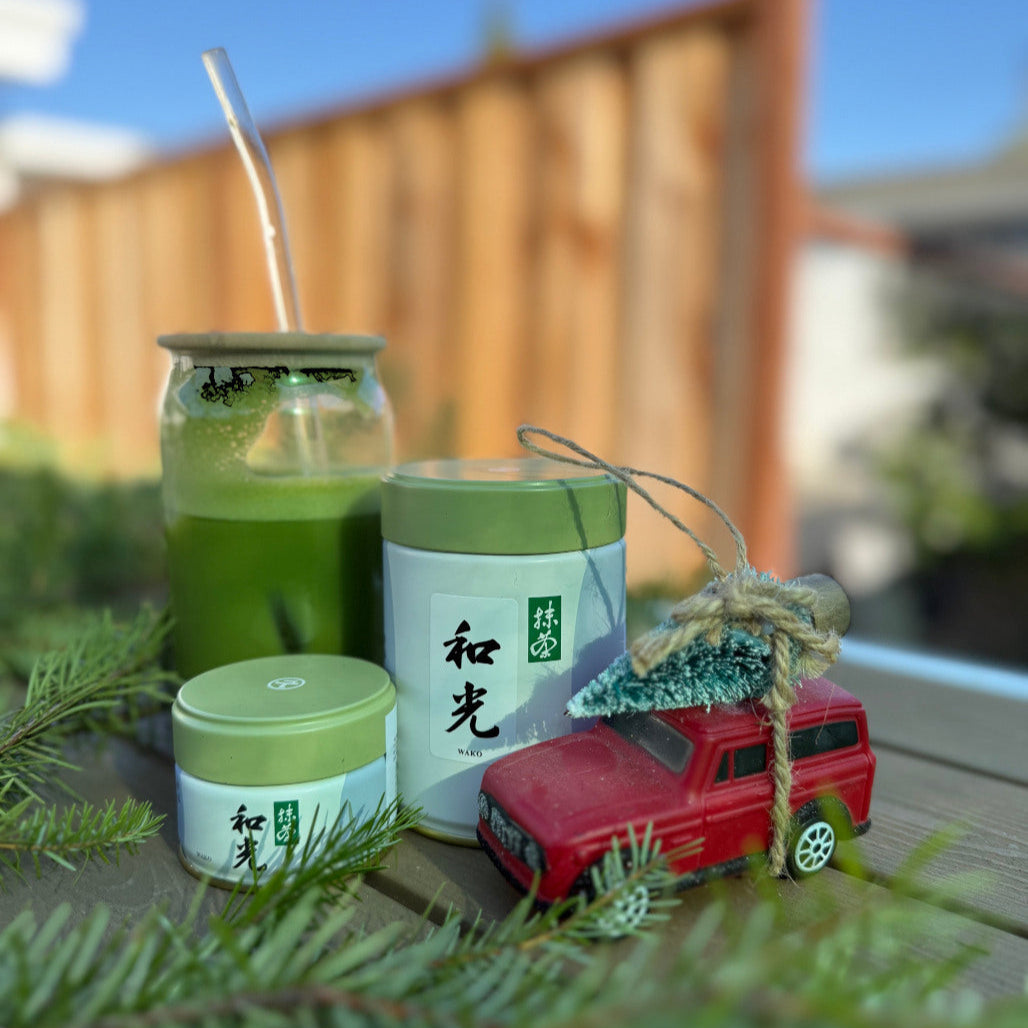 Wako Matcha - Marukyu Koyamaen - 100 Gram and 20 Gram Tin. Placed in a holiday setting with a matcha latte and a holiday ornament visible.